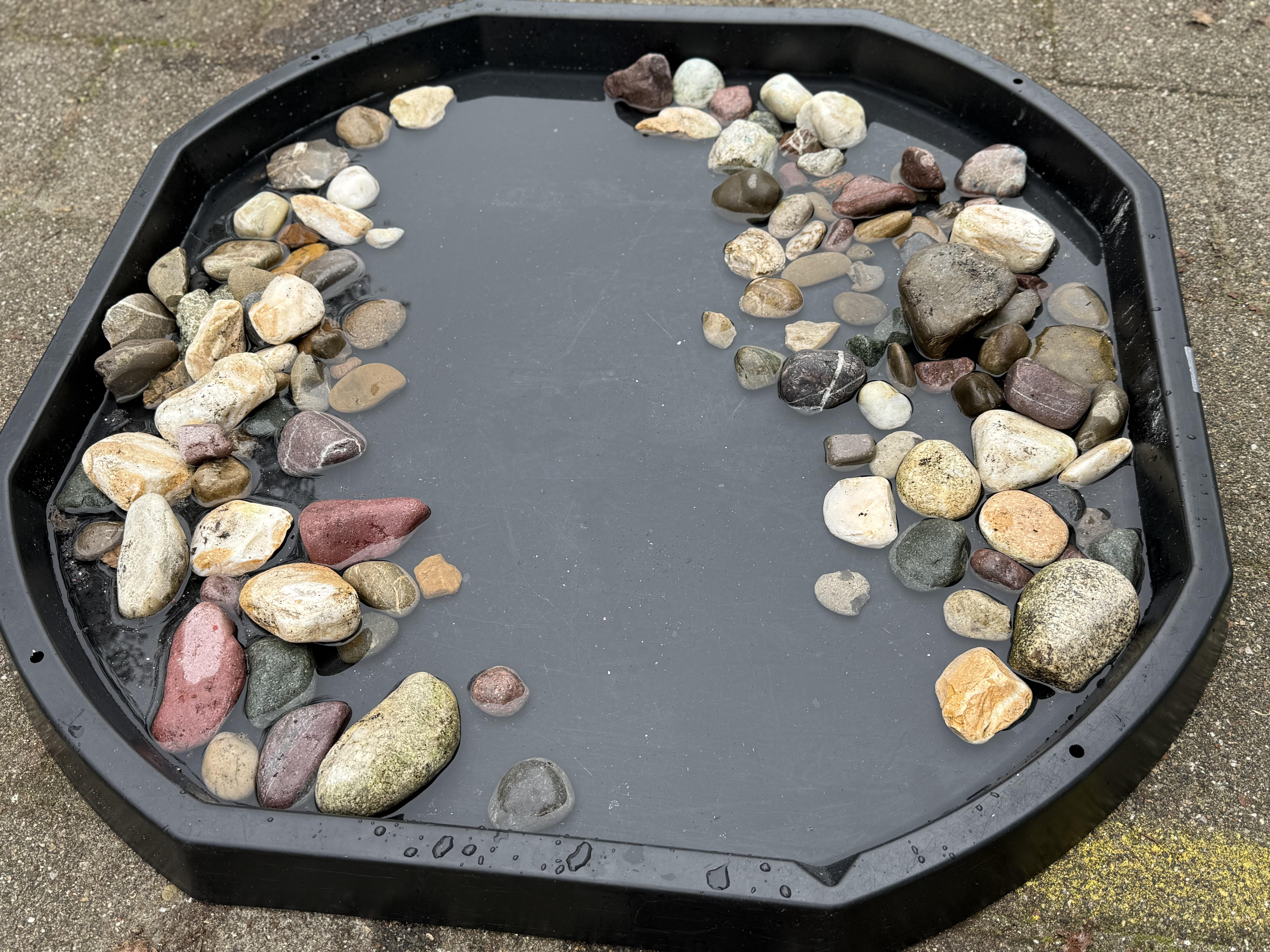 Outdoor learning — splashing through water in a tuff tray